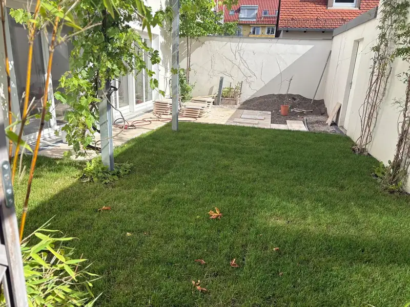 Gartengestaltung Innenhof München mit Rasen und Terrassenbereich