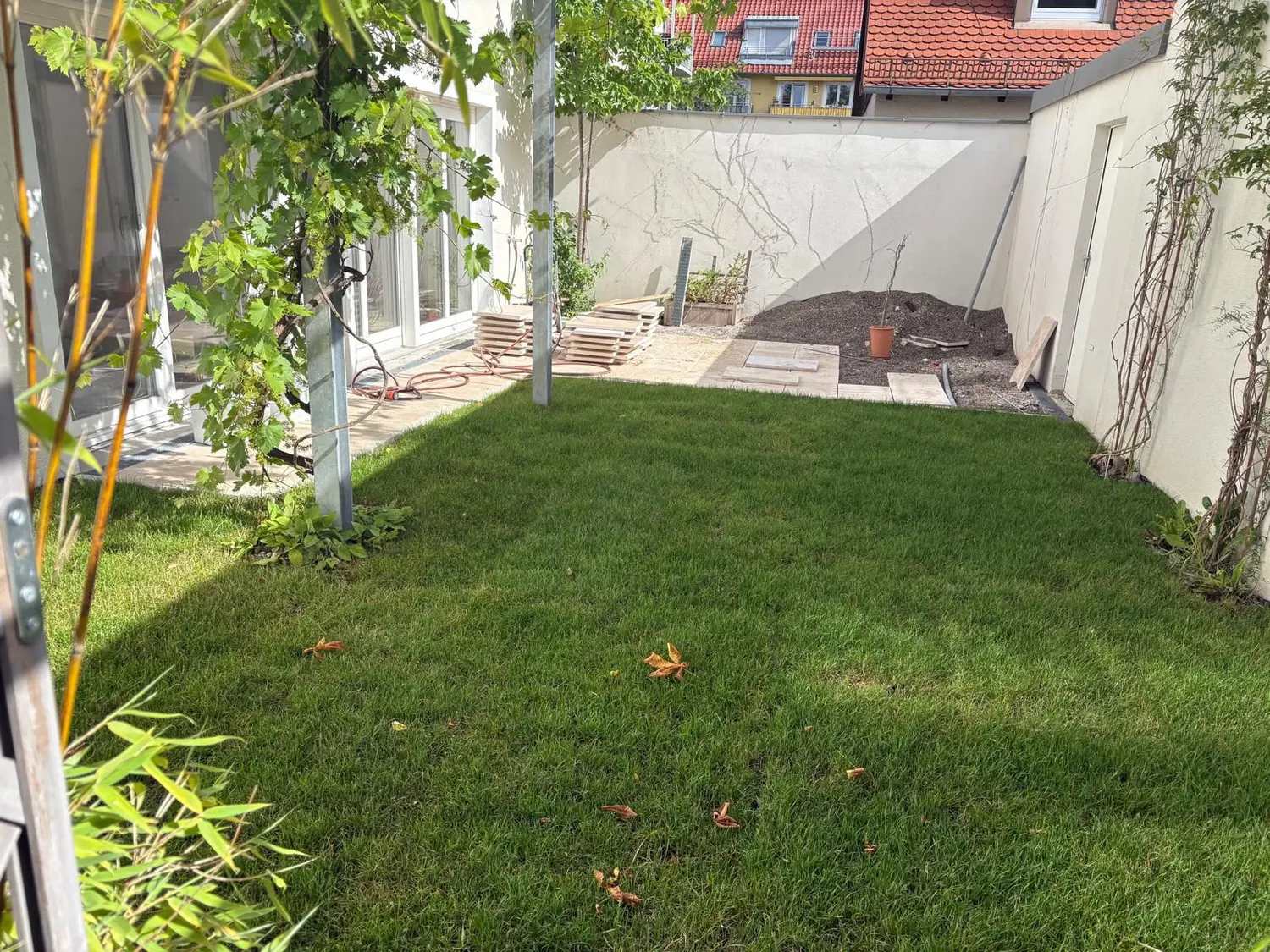 Gartengestaltung Innenhof München mit Rasen und Terrassenbereich
